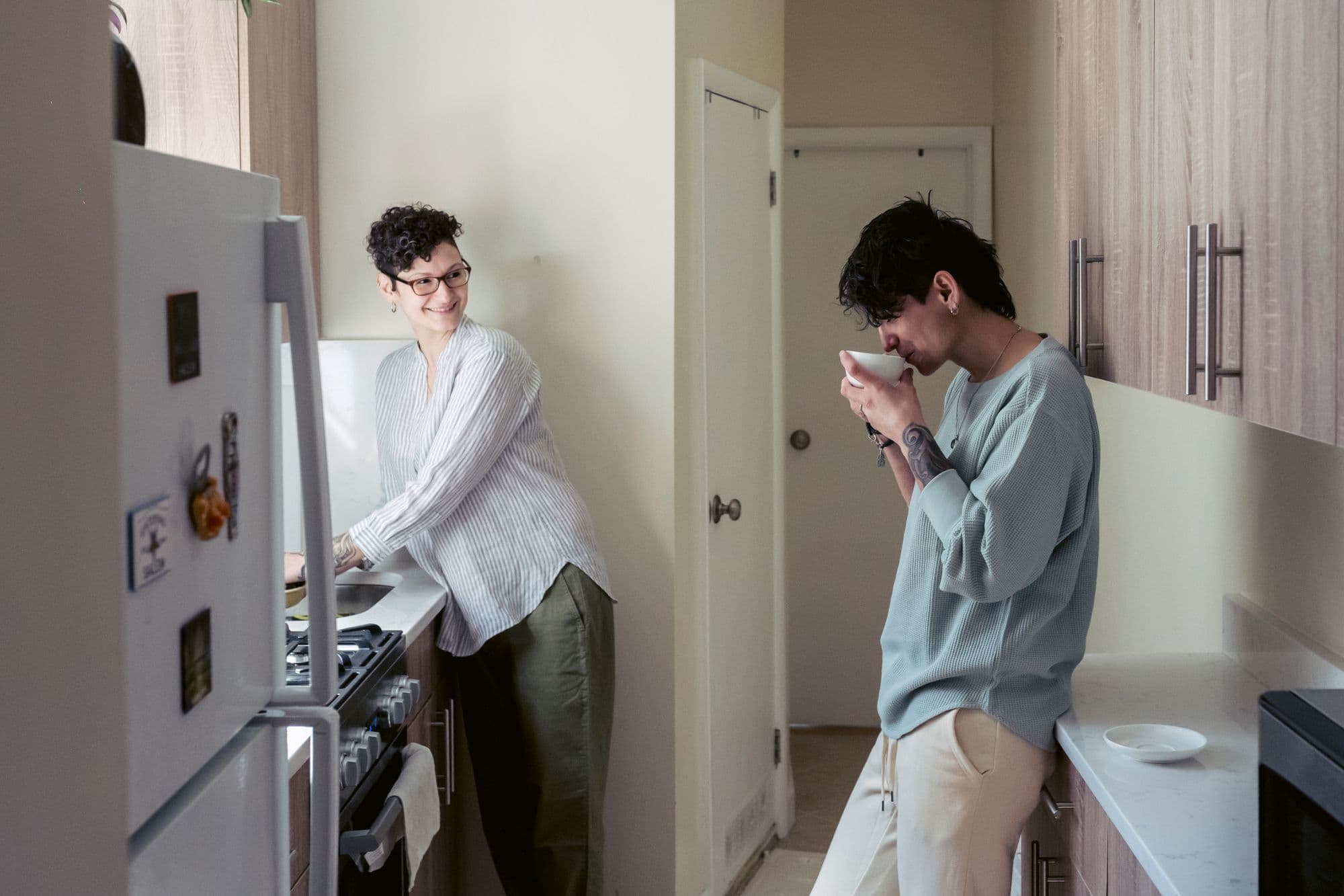 Two young adults sharing an ordinary morning in a small kitchen