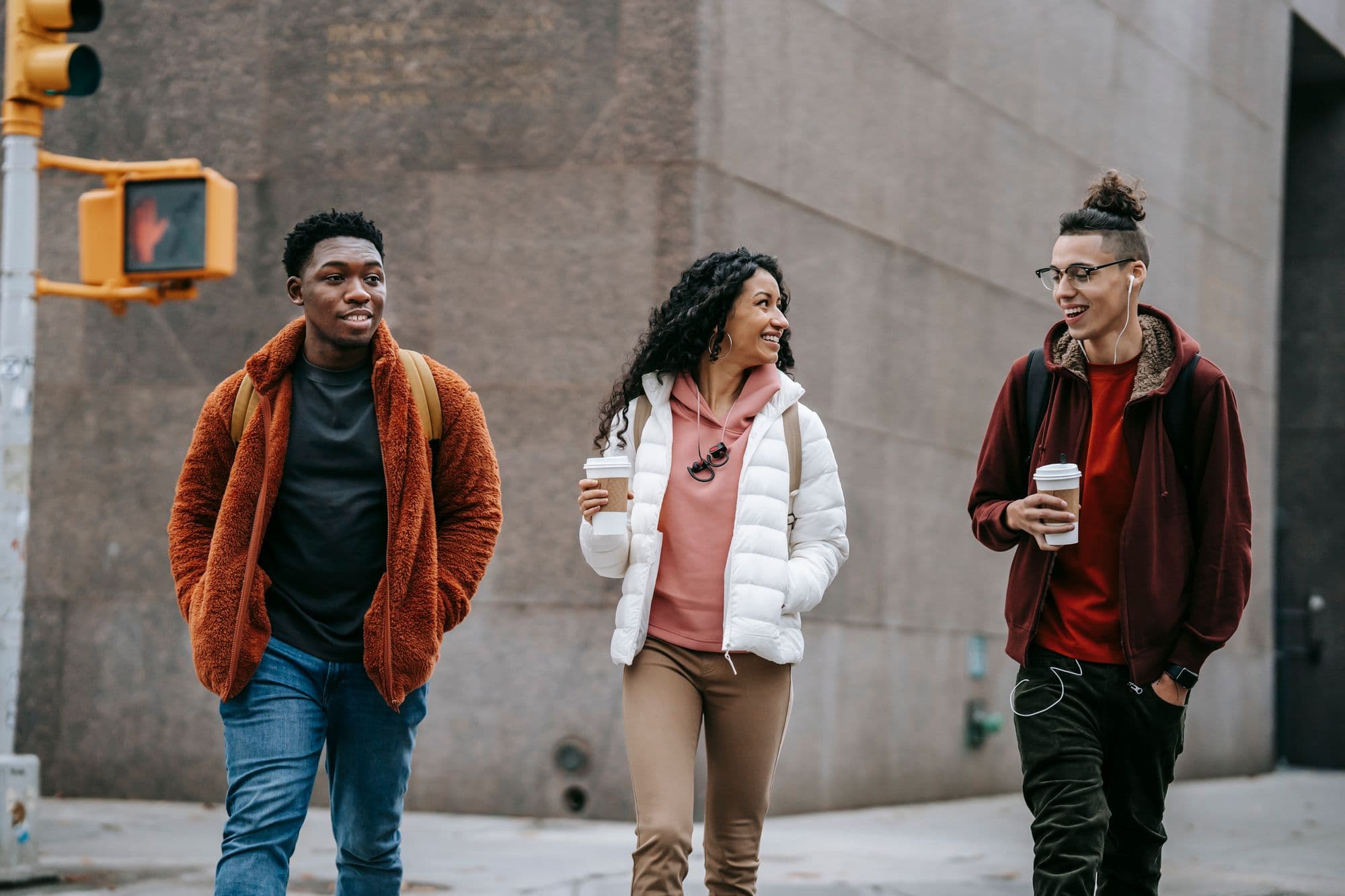 Three friends talking as they walk through a city